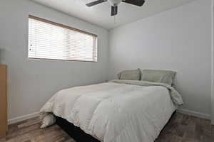 Bedroom featuring a textured ceiling, ceiling fan, and dark wood-style flooring