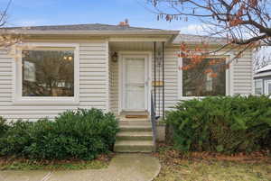 Entrance to property featuring a shingled roof