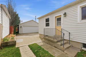 View of exterior entry with a detached garage
