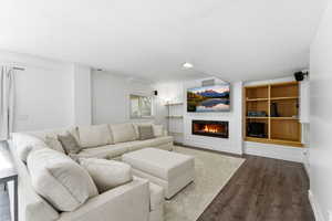 Living room with wood finished floors and a warm lit fireplace