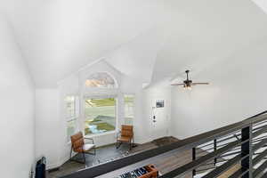Foyer featuring dark wood-style floors, vaulted ceiling, and ceiling fan