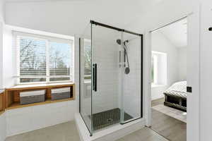 Ensuite bathroom featuring a shower stall and tile patterned flooring