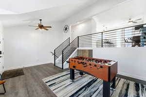 Recreation room with ceiling fan, vaulted ceiling, and wood finished floors