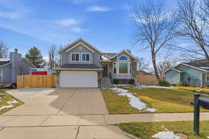 View of front facade with an attached garage, concrete driveway, and a gate