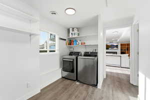Laundry area featuring light wood-type flooring and washing machine and dryer