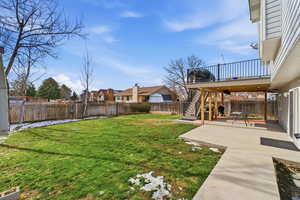 Fenced backyard featuring a patio, a deck, and a residential view