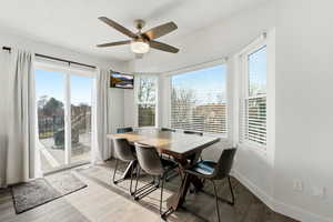 Dining space with wood finished floors and ceiling fan