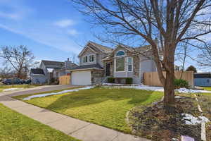 View of front of house featuring driveway, a garage, and stone siding