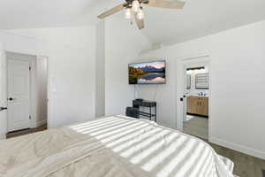 Bedroom with vaulted ceiling, wood finished floors, ceiling fan, and ensuite bathroom