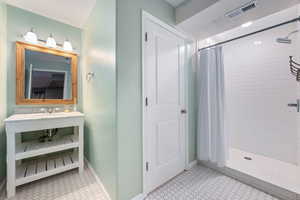 Bathroom with a stall shower and a sink