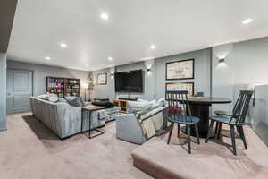 Living room featuring recessed lighting, carpet flooring, and a fireplace