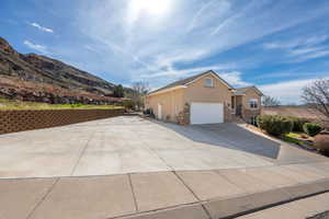 View of front facade with stucco siding, stone siding, concrete driveway, and an attached garage