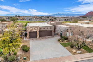 View of front of house with a garage, a mountain view, driveway, stucco siding, and a residential view