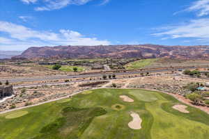 Aerial view of a golf course and a mountainous background