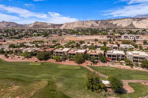 Aerial view of residential area with a mountainous background and a golf club