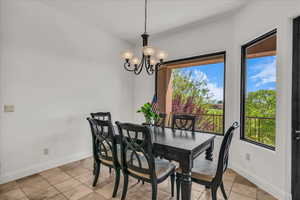 Dining room with suspended lighting and light tile patterned flooring