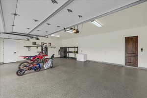 Garage featuring baseboards and a garage door opener