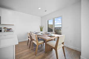 Dining room with dark wood-style floors and recessed lighting