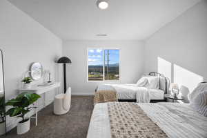 Bedroom with a mountain view and dark colored carpet