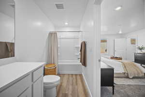 Ensuite bathroom featuring vanity, light wood-style flooring, shower / bath combo, and recessed lighting