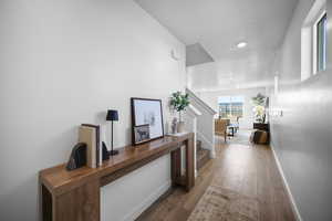 Hallway with stairs and wood-type flooring