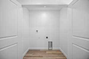 Laundry area with light wood-type flooring, electric dryer hookup, and hookup for a washing machine
