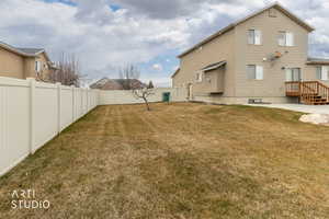 Back of property with a fenced backyard and fruit tree.