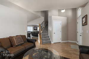 Living room featuring wood floors and lofted ceiling