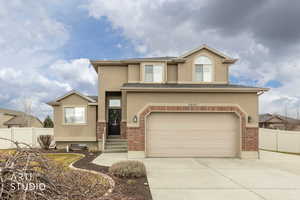 View of front of house featuring stucco siding, and concrete driveway.