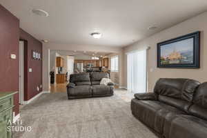 Living area with suspended lighting and light carpet