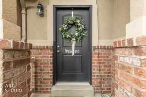 View of exterior entry with detail of stucco and brick.