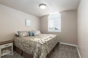 Bedroom with dark colored carpet and a textured ceiling