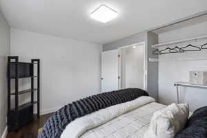 Bedroom featuring dark wood-style floors and baseboards