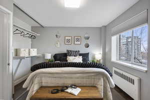 Bedroom with radiator and wood finished floors