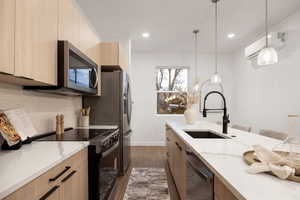Kitchen featuring modern cabinets, stainless steel appliances, light stone counters, dark wood-type flooring, and two tone color scheme