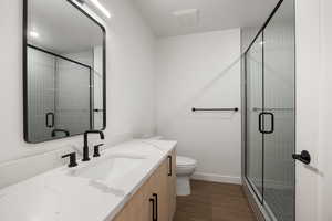 Bathroom with vanity, a stall shower, dark wood-type flooring, and a textured ceiling