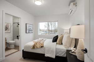 Bedroom with a mini split for heating / cooling, a textured ceiling, and connected bathroom