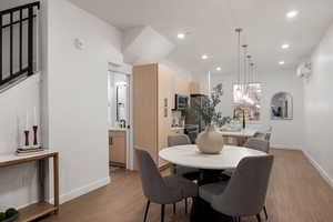 Dining area with light wood-style floors and recessed lighting