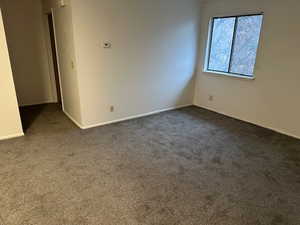Spare room with carpet and baseboards