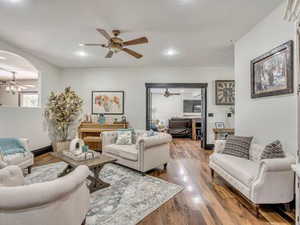 Living area with a ceiling fan, dark wood finished floors, and recessed lighting