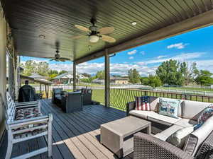 Wooden terrace with outdoor furniture and a ceiling fan