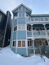Snow covered house featuring a porch