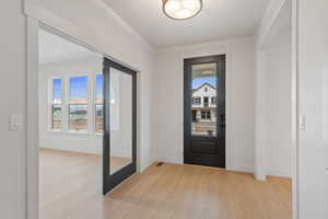 Foyer featuring light wood finished floors and baseboards
