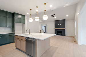 Dual tone kitchen featuring light stone counters, vaulted ceiling, stainless steel dishwasher, dual tone cabinetry, and light wood-type flooring