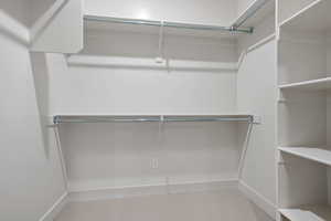 Walk in closet featuring light colored carpet