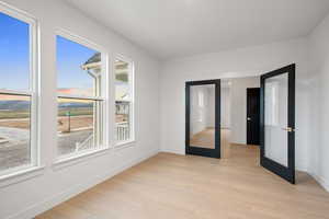 Spare room featuring light wood-style floors and french doors