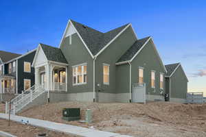 View of front of property featuring stucco siding and roof with shingles