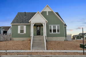 Bungalow with stucco siding and roof with shingles