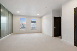 Unfurnished room with light colored carpet and recessed lighting