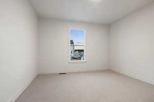 Spare room with light carpet and baseboards